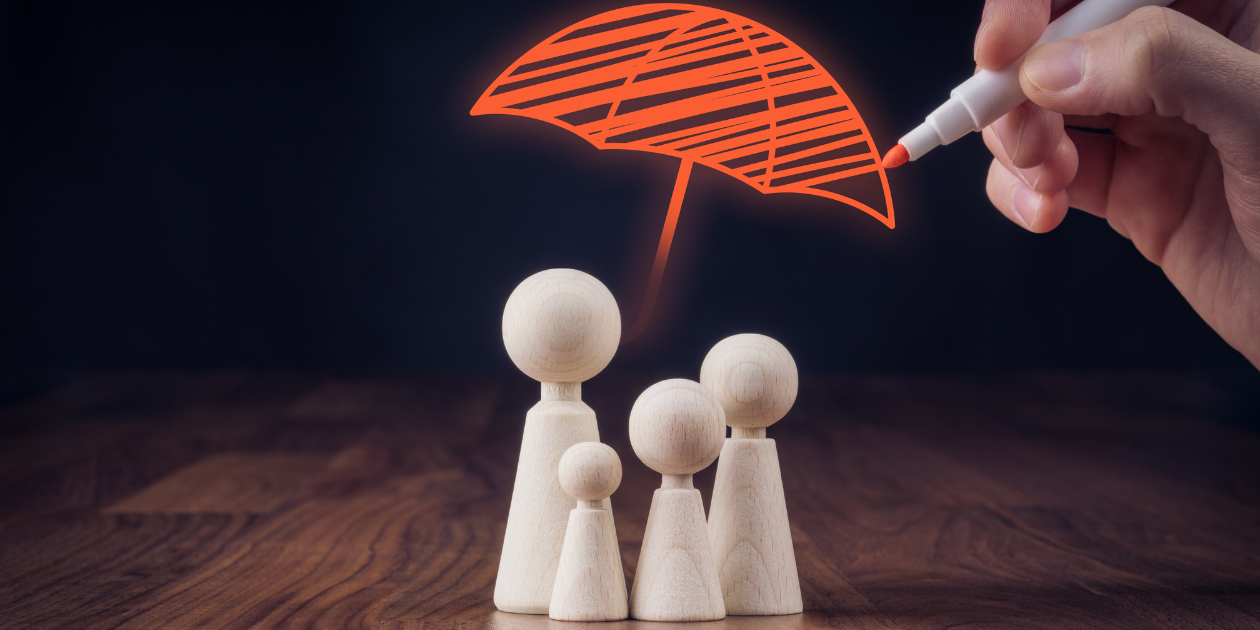 4 wooden family figures with an orange umbrella drawn above them to signify coverage