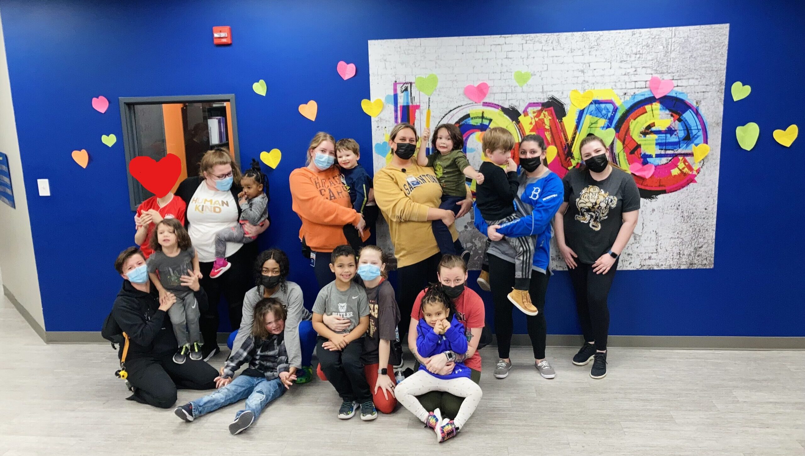 ABA staff and clients in front of the love mural