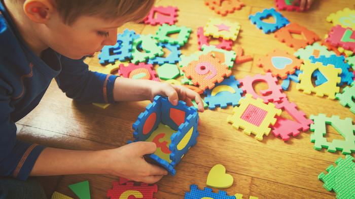 a child playing with foam puzzle pieces during ABA therapy