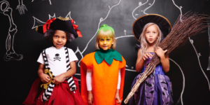 three children dressed in Halloween costumes